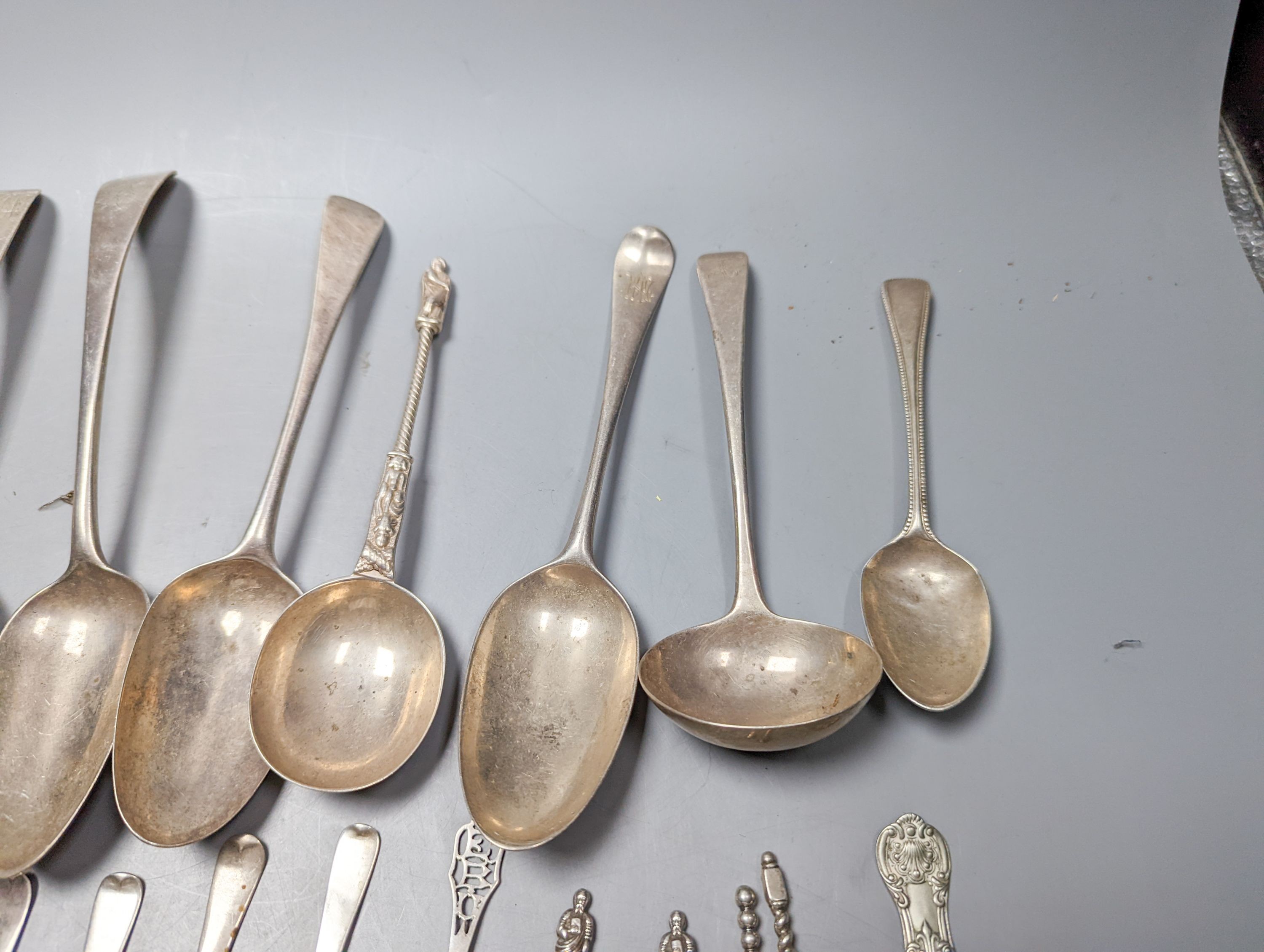 A mixed quantity of 18th, 19th and 20th century silver flatware, including tablespoons, teaspoons, sauce ladles, a 900 standard cake slice, two plated spoons and a nail implement